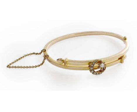 A Split Pearl Bangle, the yellow plain polished cross over bangle overlaid with a star and crescent plaque, set throughout wi