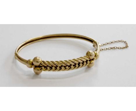 A Hinged Bangle, stamped '15', with rope work decoration centrally, measures 6.0cm by 4.8cmGross weight 11.4 grams.