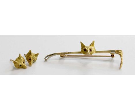 A 9 Carat Gold Brooch, in the form of a riding crop with a fox mask centrally, inset with ruby eyes, length 5.8cm and A Pair 