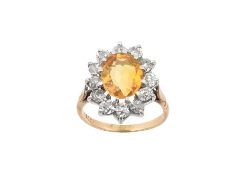 A Citrine and Diamond Cluster Ring, the oval cut citrine within a border of old cut diamonds, in white claw settings, to a ye