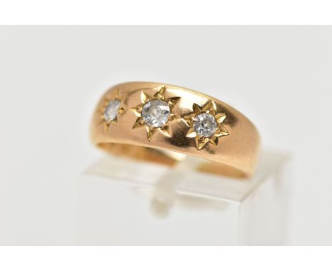 AN 18CT GOLD DIAMOND THREE STONE RING, the graduated old cut diamonds, within a star setting, to the tapered band, estimated 