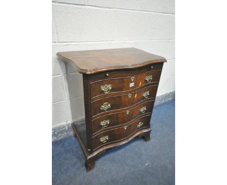 A REPRODUCTION GEORGE III STYLE MAHOGANY SERPENTINE CHEST OF FOUR LONG DRAWERS, with a brushing slide, blind fretwork to fron