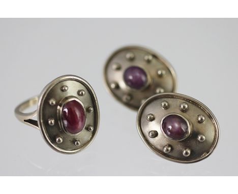 An 18ct white gold and star ruby set ring and matching earrings, London 1999, designed as a central, oval cabochon ruby withi