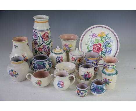 A collection of twenty pieces of Poole pottery, each brightly decorated with flowers in various patterns, including a vase 22