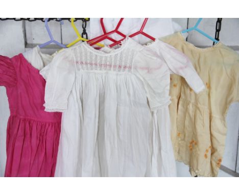 A quantity of assorted vintage dolls outfits, to include dresses, capes, vintage christening gowns, Victorian capes etc, with