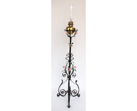 An Arts and Crafts wrought iron, copper and brass adjustable oil standard lamp, with brass reservoir on a floral frame, 140cm