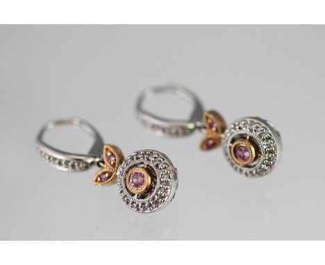 A pair of pink and white diamond set drop earrings, the central pink diamond within a white diamond set surround, all set in 