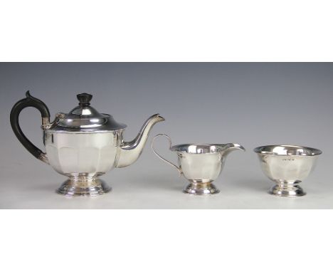 A silver three piece tea service, Viners Ltd, Sheffiled 1937, of faceted circular, pedestal form, comprising; teapot with ebo