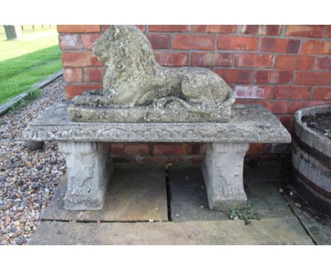 A reconstituted stone garden bench, on scroll moulded ends, 45cm H x 118cm long