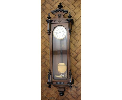 A  walnut and ebony Vienna regulator, with enamel Roman numeral dial and subsidiary seconds, with serpentine cresting, 124cm