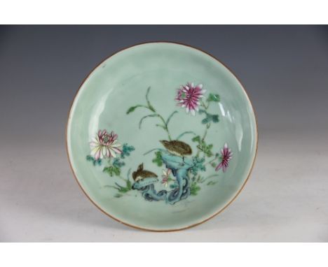 A Chinese celadon ground saucer dish, decorated in famille rose colours with two Quails perched upon branches amongst blossom