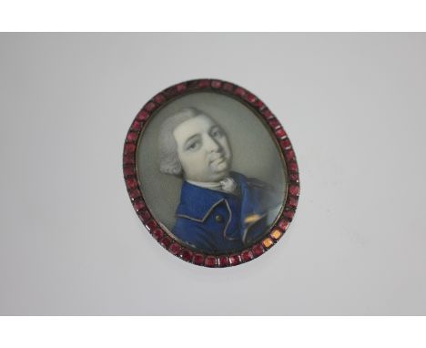 A portrait miniature inset brooch, late 18th century, watercolour on ivory depicting a gentleman in cobalt frock coat with po
