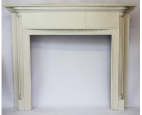 A 1920's carved wood and gesso mantle piece / fire surround, bow fronted with blind fret detailing and fluted corner columns,