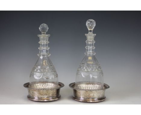 A near pair of decanters and silver plated bottle coasters, 19th century, each triple ring neck mallet shaped decanter and st