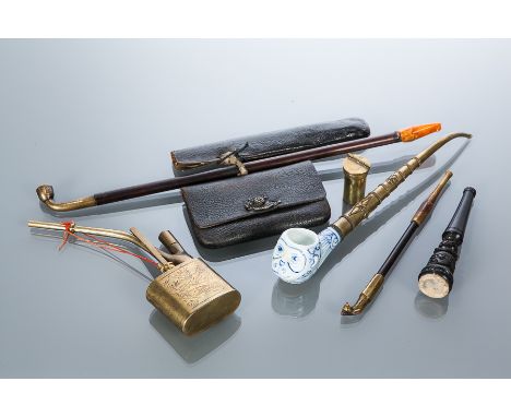FOUR CHINESE/EASTERN PIPES
the longest pipe with leather tobacco pouch, 38cm long; along with a pipe section 
