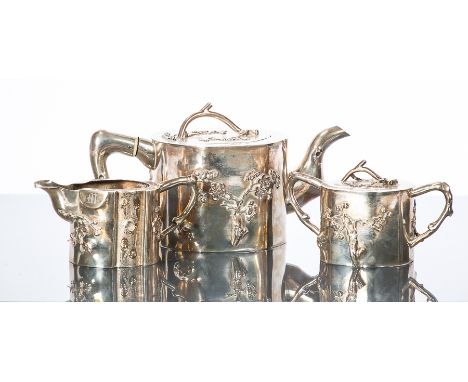 CHINESE SILVER THREE PIECE TEA SERVICE 
comprising teapot, sugar and cream, with blossom motifs in relief and wood effect fin