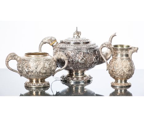 INDIAN WHITE METAL THREE PIECE TEA SERVICE 
comprising tea pot, sugar and cream, elaborate embossed and chased scrolling desi