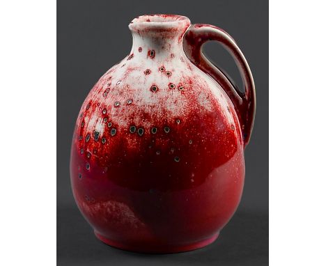 A Ruskin flambé ewer, 1933,&nbsp; of onion form, the rich crimson red glaze over an ivory ground and suffused with spots of g