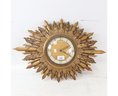A Vintage gilded sunburst quartz wall clock, overall width 56cm, working order 
