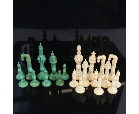 A 19th century Indian Pepys pattern part chess set, green stained and white carved ivory pieces, King height 11cm (21 pieces)