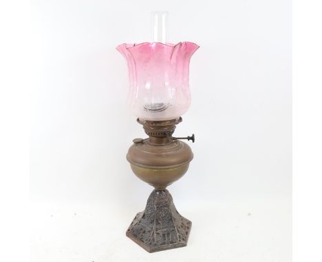 A Veritas brass oil lamp, with cast-iron base, fluted cranberry glass shade and clear glass funnel, overall height 58cm 