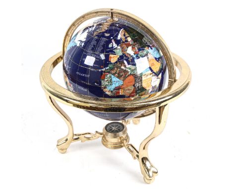 A reproduction brass and hardstone table-top terrestrial globe, with compass inset base, overall height 30cm, globe diameter 