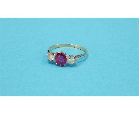 A gold ring set with central ruby and flanked by two diamonds.