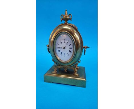 A small brass mantel clock with oval enamelled dial, stamped S. and F.  23cm high