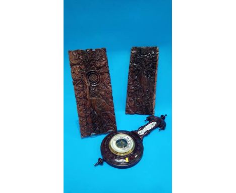A pair of carved panels and a barometer.