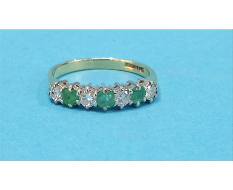 An 18ct gold diamond and emerald seven stone ring.