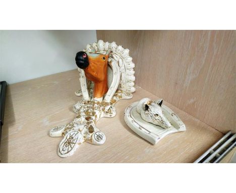 An unusual Staffordshire pottery wall shelf with a horse's head and a pottery horse shoe with a fox.
