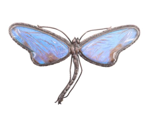 A large vintage white metal dragonfly brooch, its wings those of butterflies set under glass, 8.3 cm
