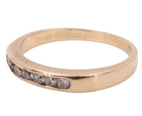 A diamond finger ring, having a line of seven channel set 2 mm brilliants, between plain shoulders in a 9 ct gold shank, Birm