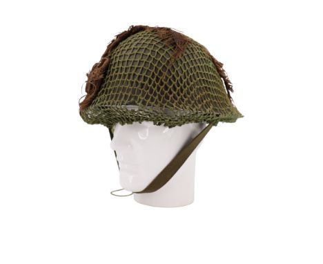 A 1950s British army Mk 4 steel helmet with net and scrim camouflage