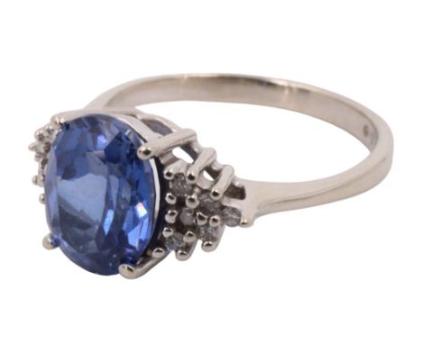 A contemporary sapphire and diamond dress ring, having a 2 carat oval flanked by adorsed sloping triangles of six diamond bri