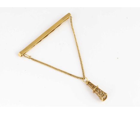 An 18ct gold South American tie slide, supporting a chain and pendant drop of oil rig, 6cm, 8.9g