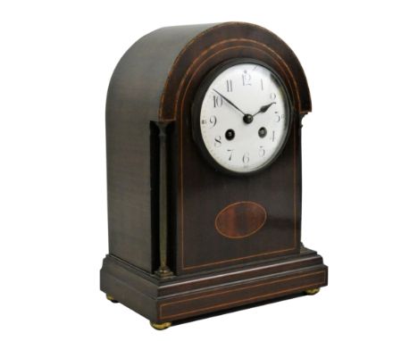 An Edwardian mahogany and boxwood inlaid mantel clock, the white enamel dial with black Arabic numerals, the French movement 