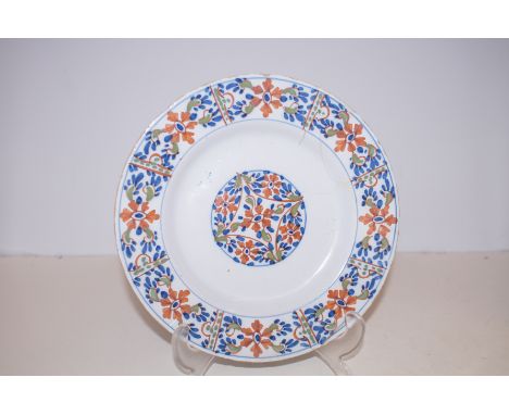 An early 18th century London delftware plate circa 1720, probably Lambeth, painted with blue and red flowers. A/F