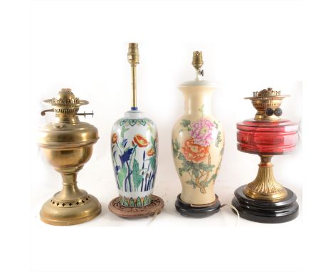 A Victorian oil lamp base, ruby glass reservoir, 34cm; another oil lamp base, and four table lamps. (Qty: 6)