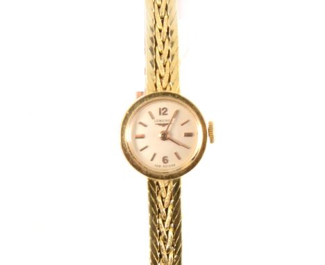 Longines - a lady's 18 carat yellow gold bracelet watch, the circular champagne baton dial with arabics at 12 and 6 in a 15mm