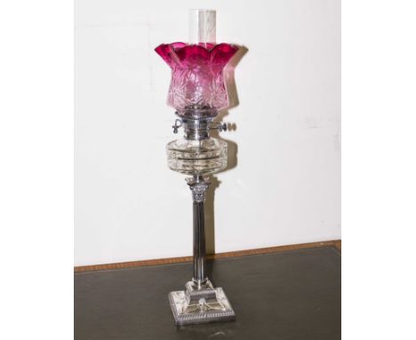 A Georgian hall marked silver Corinthian column oil lamp with cranberry glass shade