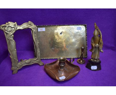 A brass tray having an embossed design, a copper chamber stick and brass photo frame