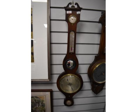 An antique banjo style barometer having a rose wood case and bulls eye mirror