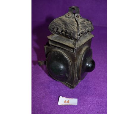 An antique brass cased candle lantern or chamber stick having green bullseye glass windows, measuring 15cm high
