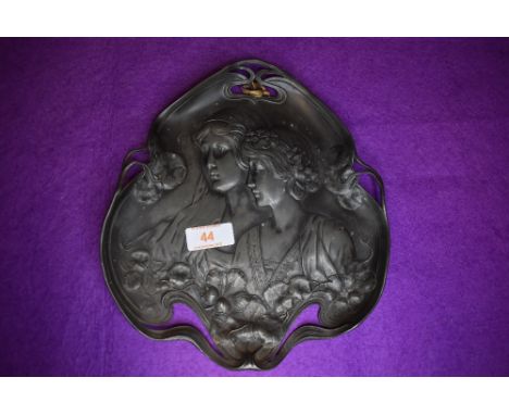 An art nouveau design metal pewter serving tray decorated with lily leaf and portrait design.&nbsp;
Some age related wear no 