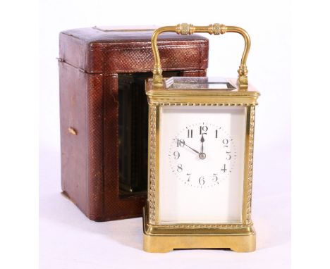 French carriage clock in typical brass case with carrying case. 18cm tall.