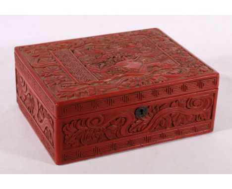 Chinese cinnabar lacquer box, the top carved with a scroll shaped panel of houses in a woodland setting, on a ribbon floral g