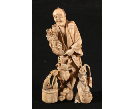 Japanese ivory carving of a vegetable seller, a small girl holding a flower by his side, and a crab crawling up his leg, 13.5