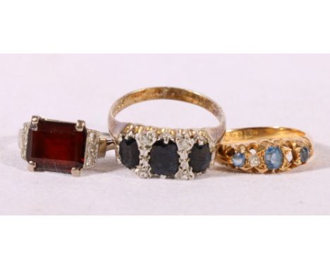 Unhallmarked white metal garnet and diamond ring, size K, 4.2g, 18ct gold diamond and blue stone ring, size M, 3.1g and an un