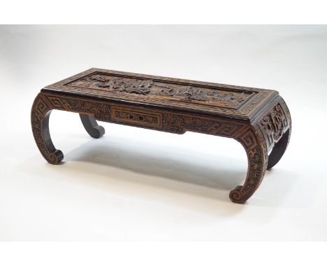 A Chinese low table with scroll ends, profusely carved with sailing ships among a mountainous landscape, 34cm high x 102cm wi